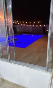 ein Swimmingpool, nachts durch ein Fenster gesehen in der Unterkunft Casa Acacías Meta con Piscina y Jacuzzi in Acacías