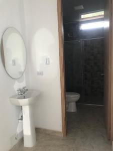 ein Badezimmer mit Waschbecken, Spiegel und Toilette in der Unterkunft Casa Acacías Meta con Piscina y Jacuzzi in Acacías + 3 Fotos