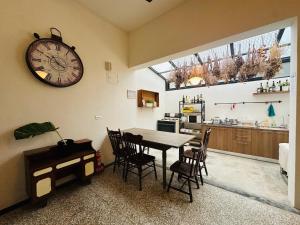 una sala da pranzo con un tavolo e un orologio a parete di Liu Xu Homestay ll a Tainan