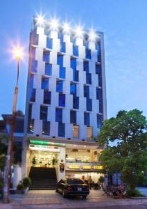 a building with a car parked in front of it at Blue Beach Hotel Danang in Da Nang