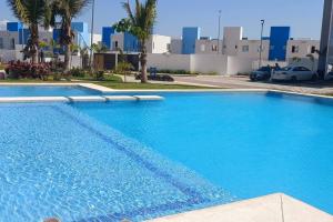 a large blue swimming pool in front of a building at Espectacular y Nuevo in Gallinero