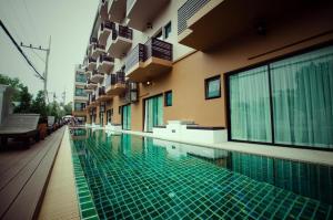 a swimming pool in front of a building at Maytara Hotel in Pattaya South