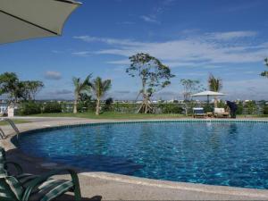 ein Swimmingpool mit Stühlen und einem Sonnenschirm in der Unterkunft Daosavanh Resort & Spa Hotel in Savannakhet
