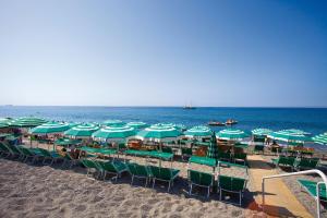 a bunch of chairs and umbrellas on the beach at Hotel Parco Smeraldo Terme in Ischia
