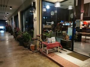 a bike parked in front of a store window at Supak Hotel in Kalasin