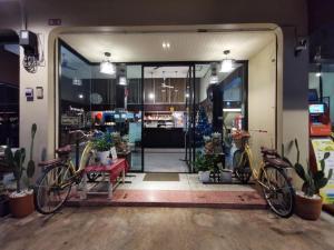 a store front with two bikes parked in front of it at Supak Hotel in Kalasin