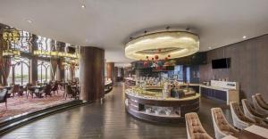 東莞市にあるDongGuan JOYC Hotel のバーとテーブルと椅子のあるレストラン