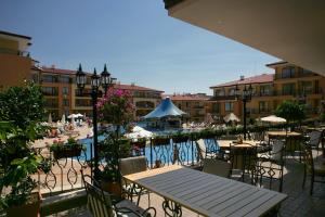 an outdoor patio with tables and chairs and a pool at Apartcomplex Panorama Dreams in Sveti Vlas