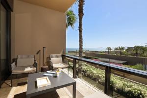 a balcony with a table and chairs and the ocean at JW Marriott Los Cabos Beach Resort & Spa in San Jos&eacute; del Cabo