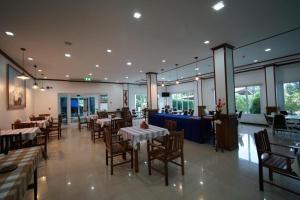una sala da pranzo con tavoli e sedie in un ristorante di Sea Mountain Khanom Hotel a Ban Phang Phrao