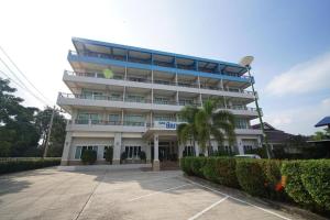 un grande edificio bianco con una palma di fronte di Sea Mountain Khanom Hotel a Ban Phang Phrao