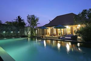 
a hotel room with a pool and a balcony at The Purist Villas & Spa Ubud in Ubud
