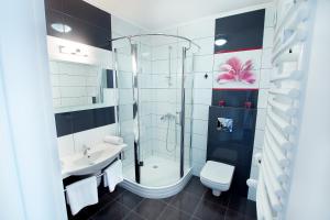 La salle de bains est pourvue d'une douche, d'un lavabo et de toilettes. dans l'établissement Portobello, à Ustka