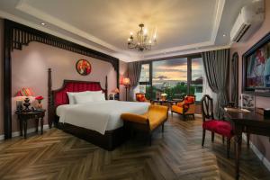 a hotel room with a large bed and a desk at Acoustic Premium Hotel & Spa in Hanoi