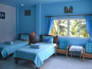ein blaues Zimmer mit 2 Betten und einem Fenster in der Unterkunft Sairougn Seaview Hotel in Ban Ko Kwang