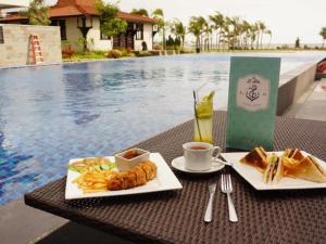 two plates of food on a table next to a pool at D'Season Premiere Hotel in Kesembu