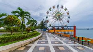 a ferris wheel in a park with benches and a ride at Lovina Inn Hotel Batam in Nagoya