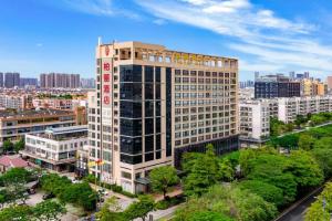 a tall building with trees in front of a city at Park Lane Hotel in Shunde