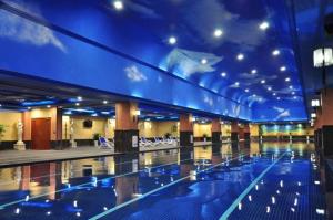 a large swimming pool with blue lighting in a building at Chongqing Huachen International Hotel in Chongqing
