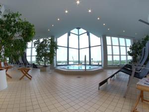 ライプツィヒにあるAtlanta Boardinghouse Leipzigの窓のある建物内に位置する広い客室で、プールが付いています。