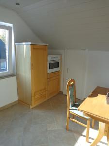 a kitchen with a table and a wooden cabinet and a table and chair at Exclusive Apartment - Rees in Rees