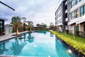 a swimming pool in front of a building at UDTel Boutique Hotel Udonthani in Udon Thani