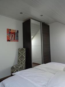 a bedroom with a bed and a chair next to a mirror at Exclusive Apartment - Rees in Rees