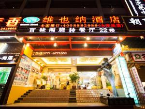 a building with a statue of a man with a baseball bat at Vienna Hotel Nanning Train Station in Nanning