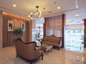 a lobby with a couch and a table and chairs at GreenTree Inn GuangDong JieYang Bus Terminal Station RongHua Avenue Business Hotel in Jieyang