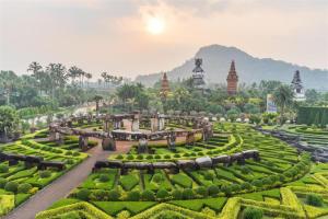 a garden with a view of a hill in the background at Baan Pimpisa in Pattaya Central