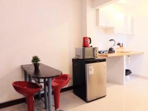 a small kitchen with a small table and red chairs at Departamentos Céntricos en Lima in Lima