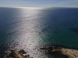an aerial view of the ocean with the sun reflecting on the water at Apartamento Torre Alacant in Alicante