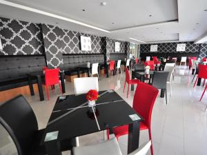 a dining room with black tables and red chairs at Tanzeno Hotel in Nong Khai