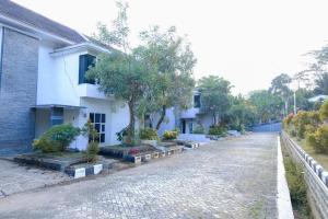a cobblestone street in front of a white building at Capital O 887 Green Hill Hotel And Convention Center in Jember
