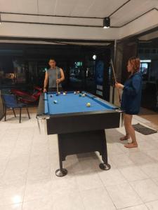 a man and a woman playing a game of pool at Czone Hostel in Koh Tao