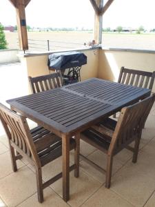 a wooden table and chairs on a porch with a table and benches at le loft de Nana in Osthouse