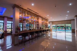 een bar met barkrukken in een ruimte met een zwembad bij phatra boutique hotel in Udon Thani