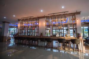 een bar met barkrukken in een grote kamer bij phatra boutique hotel in Udon Thani +32 foto's