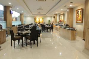un restaurant avec des tables et des chaises et un bar dans l'établissement Atrium Premiere Cilacap, à Cilacap