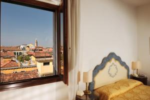 a bedroom with a view of a city from a window at San Marco Palace in Venice