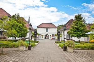 a cobblestone street in a town with houses and trees at Hotel Adilla Syariah Ambarukmo in Yogyakarta