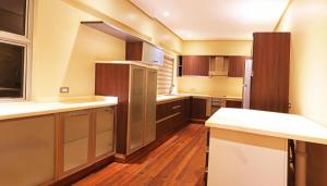 a large kitchen with wooden floors and a refrigerator at The Oriental Luxury Suites Tagaytay in Luksuhin
