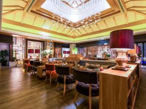 上海市にあるHuana Hotel Minhang Shanghaiの部屋にテーブルと椅子があるレストラン