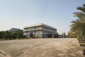a large building with a palm tree in front of it at OYO 75394 Sakthong Grand Hotel in Chiang Khong