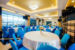 a banquet hall with blue chairs and a table with flowers at Facade Hotel in Baranghauon
