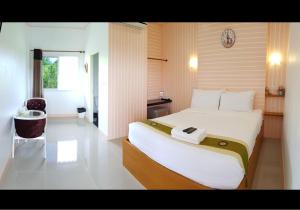 The Aam resort في بانغ ساري: غرفة نوم بسرير كبير وساعة على الحائط