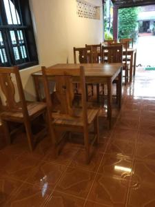 a wooden table and chairs in a room at Sysomphone G.H in Luang Prabang