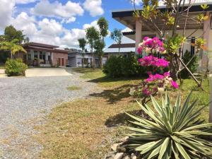 a house with pink flowers on the side of it at Suanrak Resort in Suphan Buri