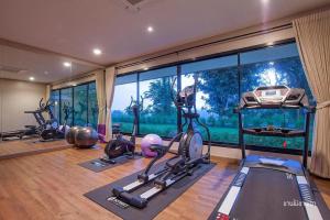 ein Fitnessstudio mit mehreren Ergometern und einem großen Fenster in der Unterkunft Nan Boutique Resort in Ban Hua Wiang Nua
