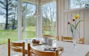 a dining room with a white table and a window at 2 Bedroom Lovely Home In Sæby in Sæby